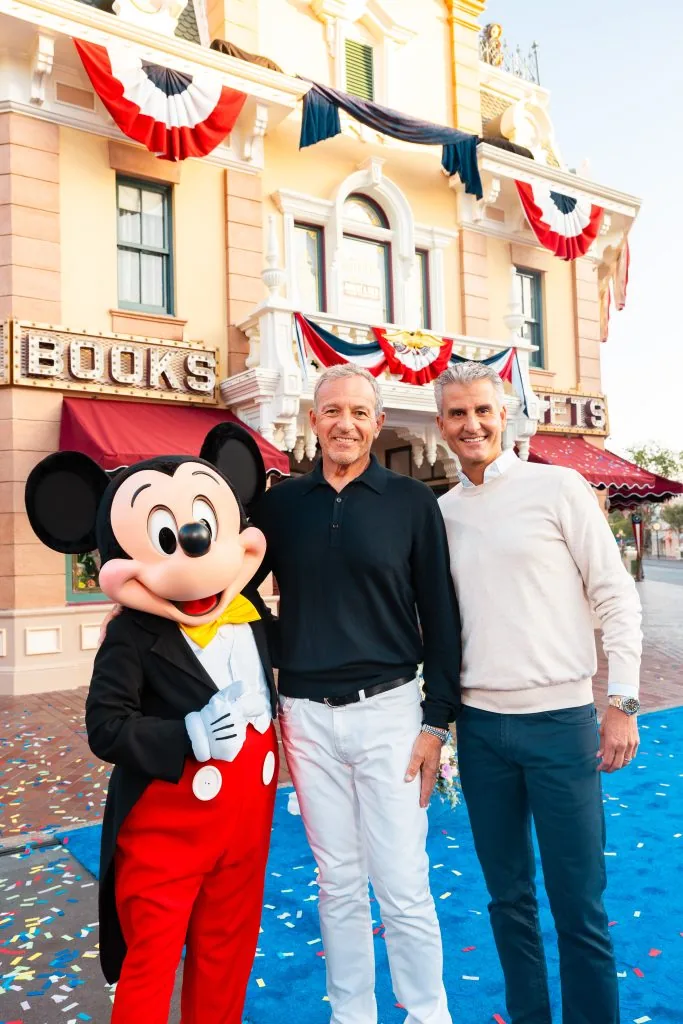 Mickey Mouse joins Bob Iger and Josh D'Amaro outside the Emporium.
