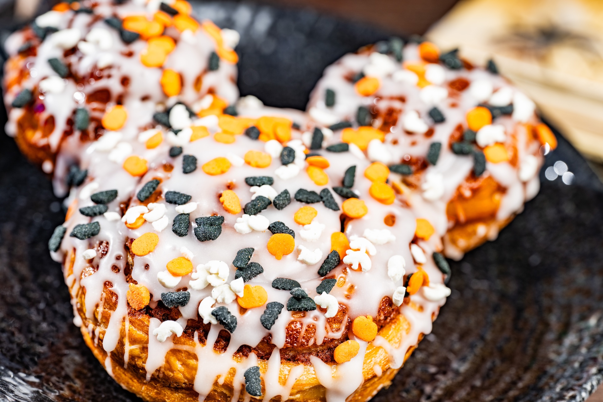 Mickey Cinnamon Roll with white icing and Halloween sprinkles from Main Street Bakery
