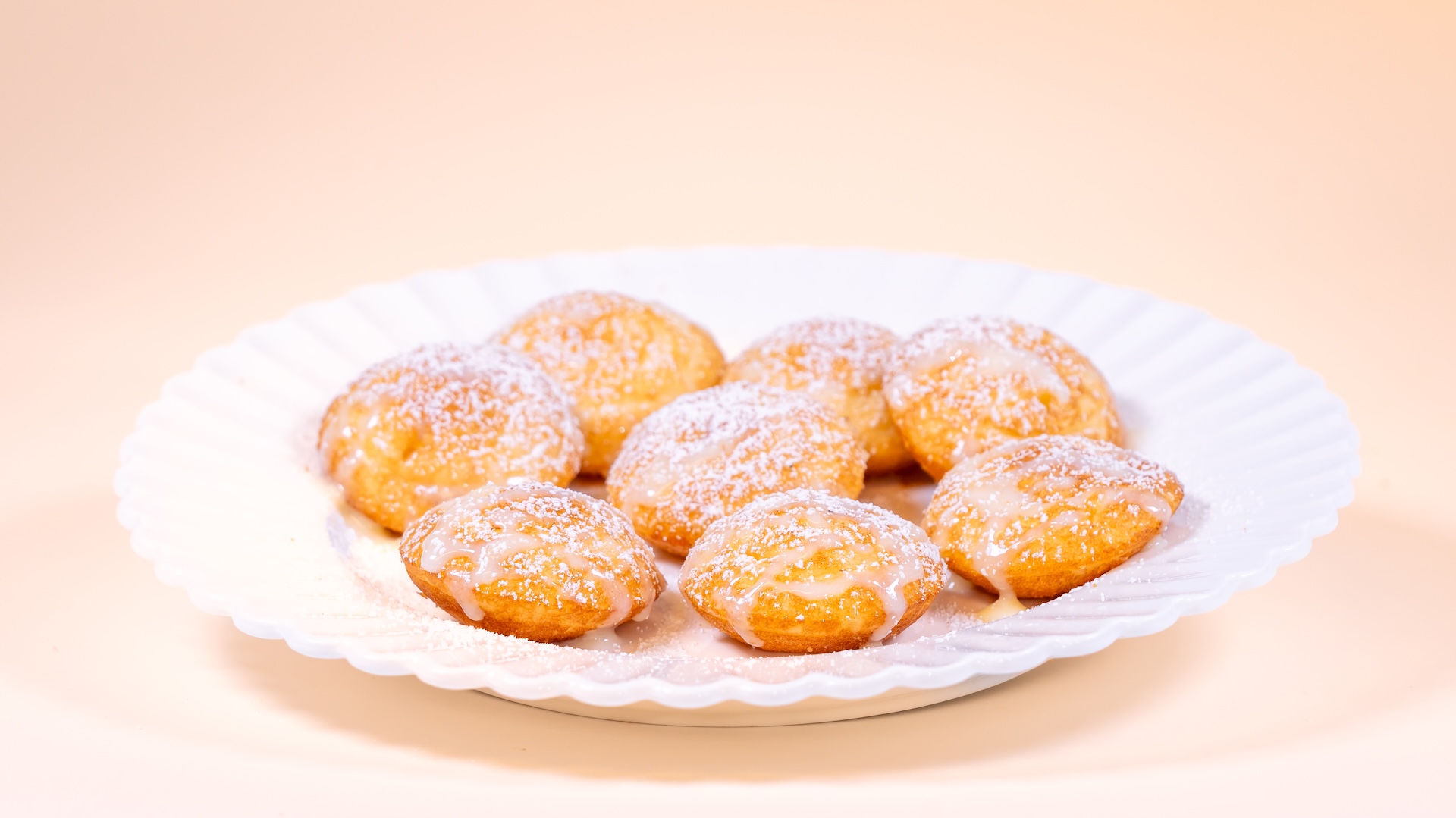 Poffertjes mini Dutch pancakes topped with buttered condensed milk and powdered sugar